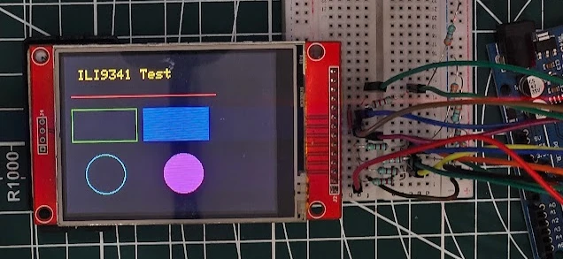 Image shows the ILI9341 display printing text and drawing simple shapes like lines, rectangles, and circles.